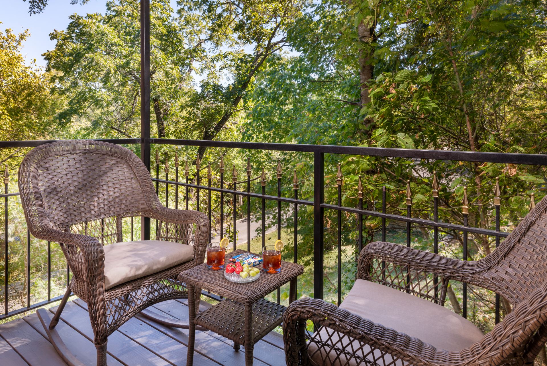 Private balcony with two wicker chairs and small occasional table overlooking East Mountain.