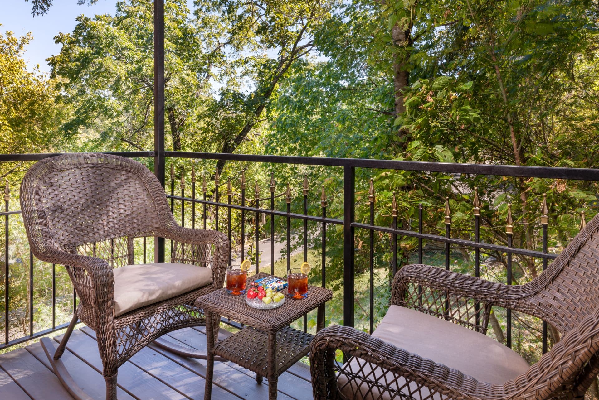 Private balcony with two wicker chairs and small occasional table overlooking East Mountain.