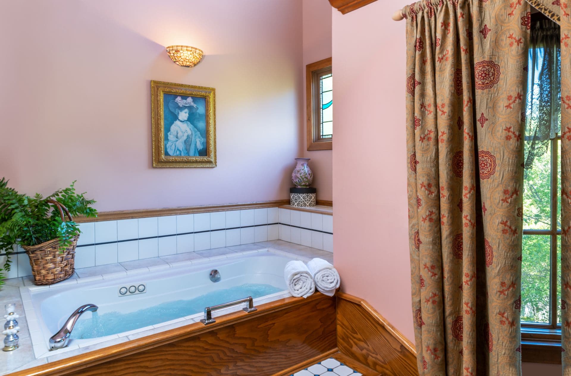 Bathroom with soaking Jacuzzi tub bordered with white and gray tiles.